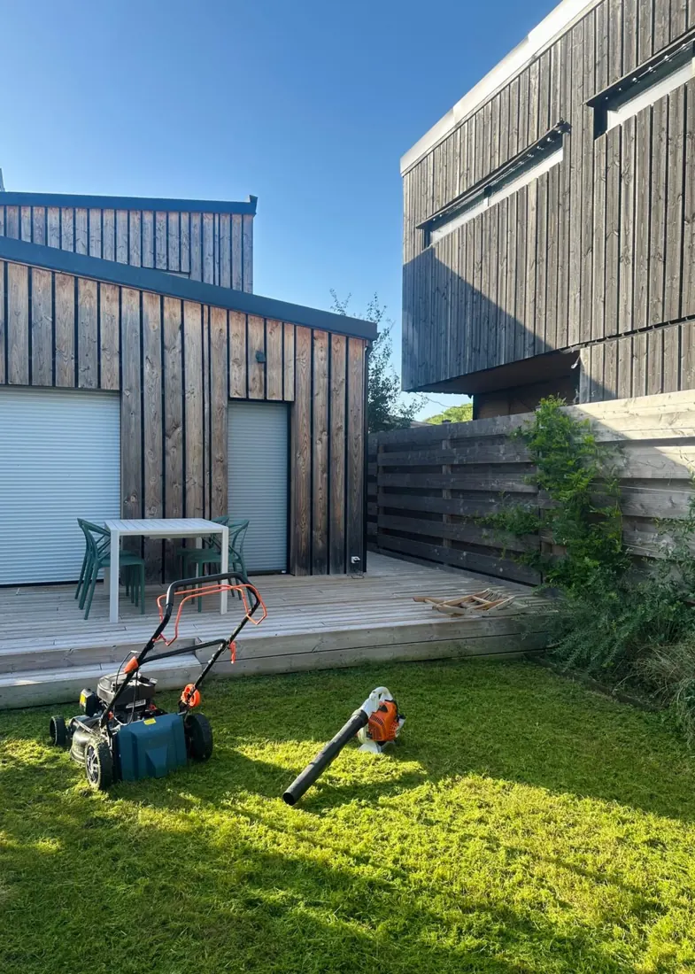 Pelouse tondue devant une terrasse en bois